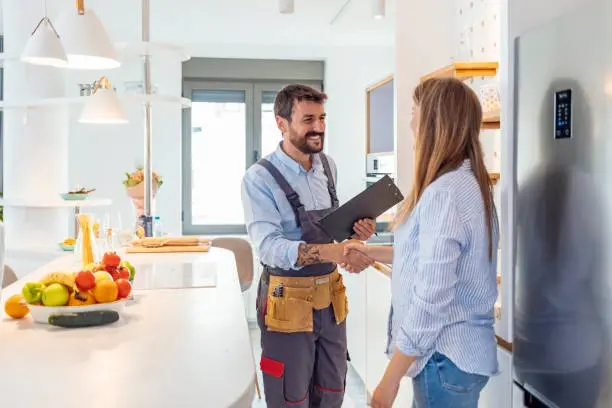 Homeowner and contractor shaking hands in a newly remodeled kitchen in Knoxville, TN after project completion