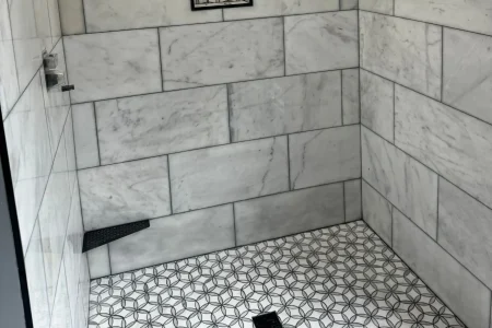 bathroom-remodel-subway-tile-knoxville.webp Bathroom remodel in Knoxville with white subway tile walls, glass enclosure, and brushed gold finishes