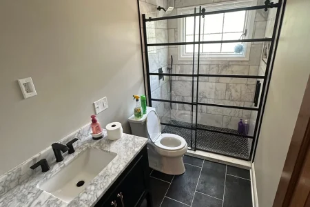 modern-bathroom-remodel-knoxville-tn.webp Modern bathroom remodel in Knoxville, TN featuring floating vanity, glass shower, and matte black fixtures