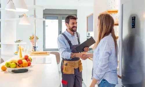homeowner-contractor-handshake-kitchen-knoxville-tn.webp Homeowner and contractor shaking hands in a newly remodeled kitchen in Knoxville, TN after project completion