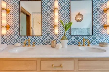 bathroom-remodel-sink-framed-mirror-knoxville.webp Bathroom remodel in Knoxville featuring white sink vanity with black framed mirror and sconce lighting